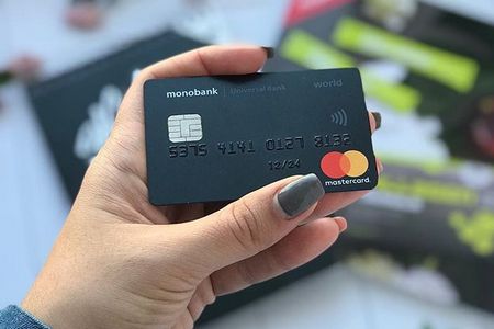 Карта монобанка в руке у девушки