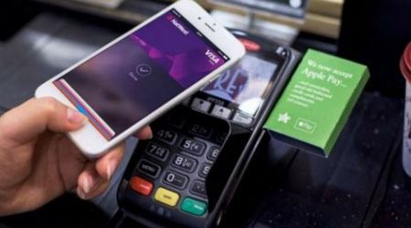 на фото терминал и смартфон совершающий проплату